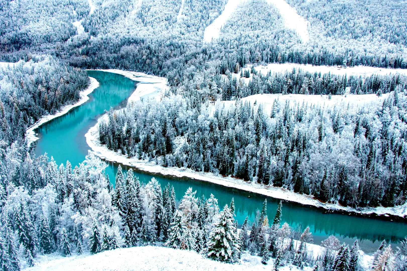 冬季雪林与蓝色河湾